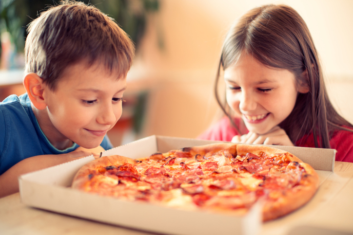 chłopiec i dziewczynka mają pizzę